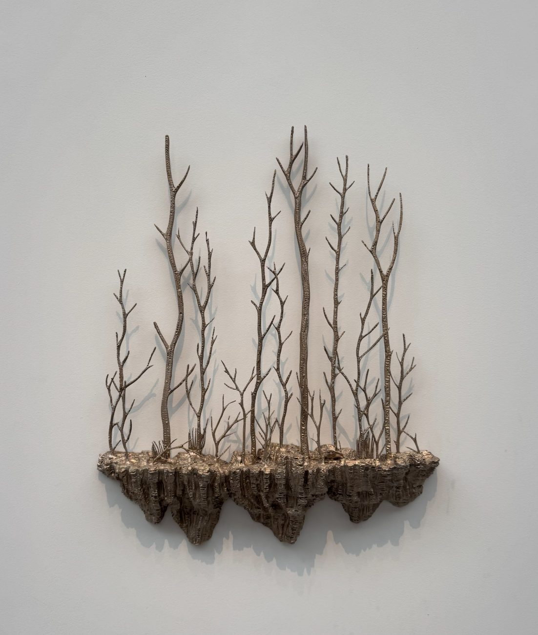 Sculpture murale en bronze évoquant des arbres