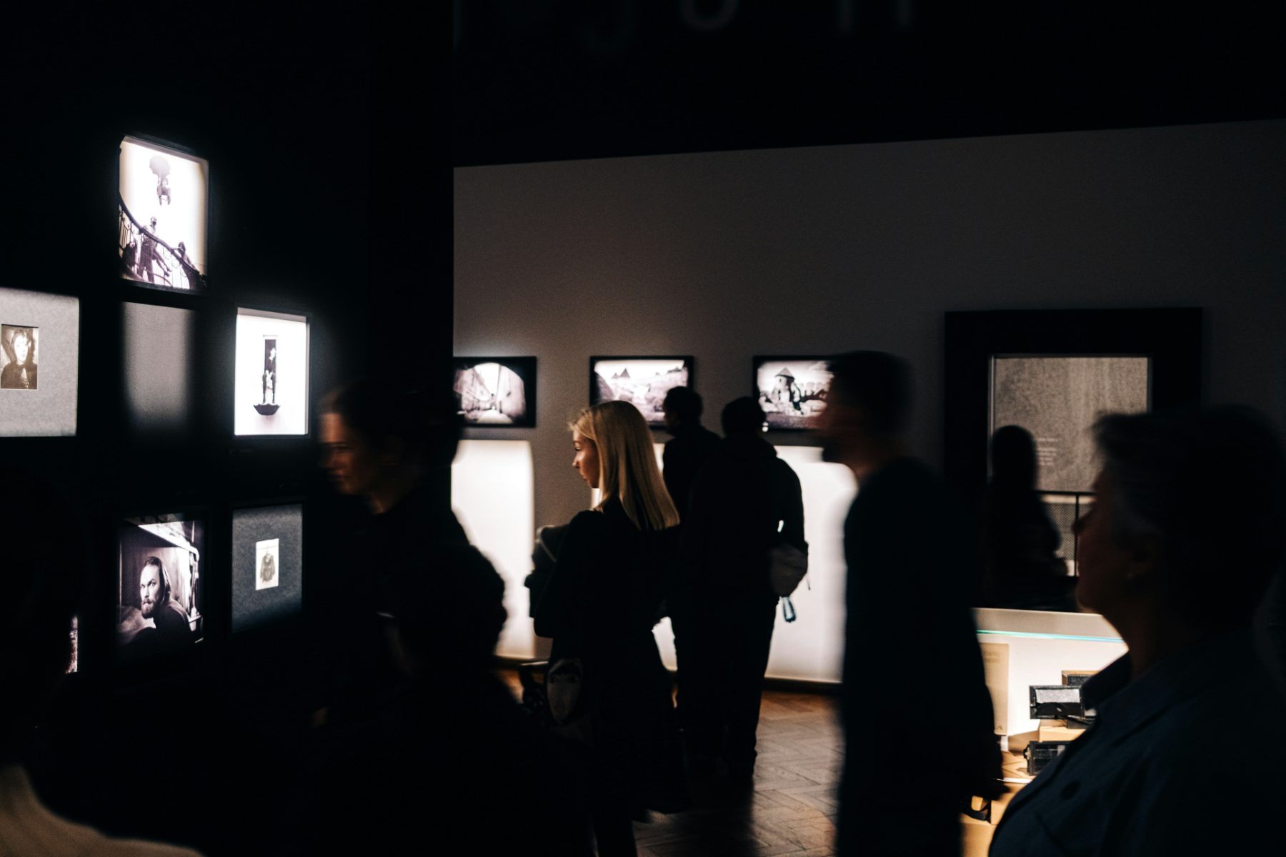 Visiteurs dans une galerie d'art contemporain, à la lueur des œuvres