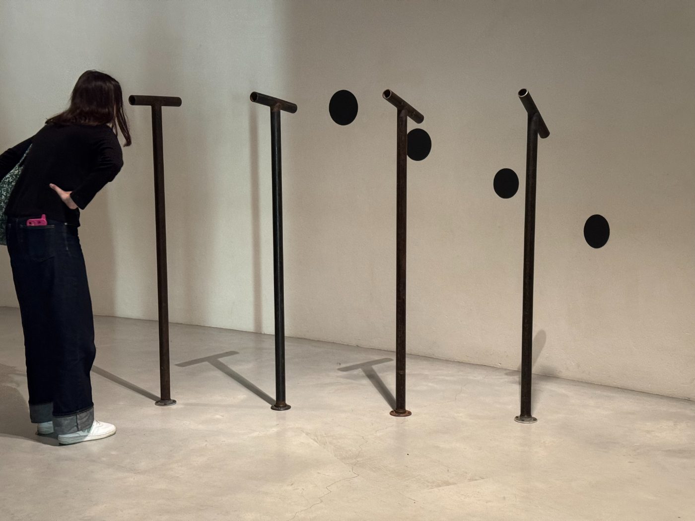 Visiteuse observant une installation de sculptures